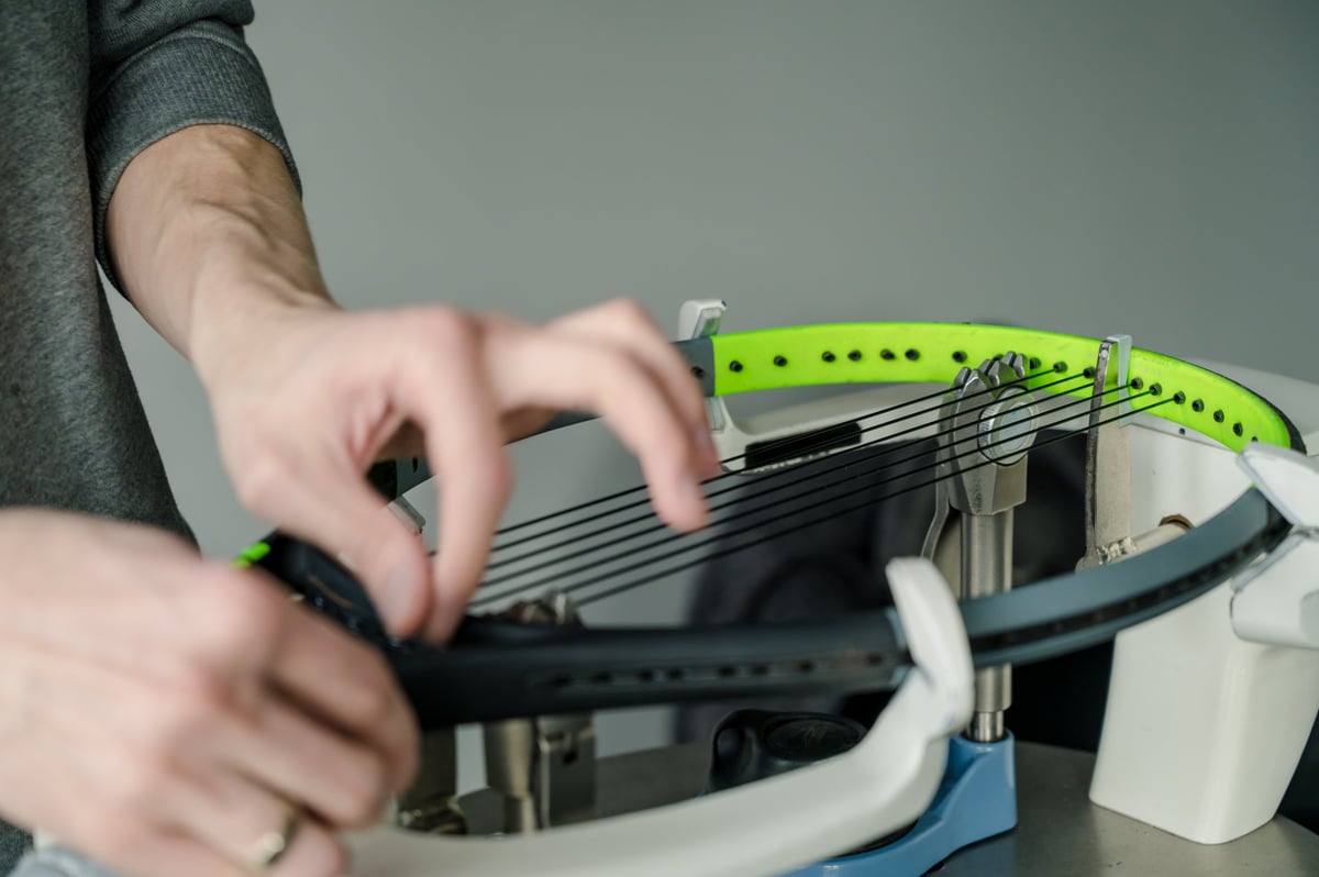Close-up of a tennis racket on an electronic stringing machine before a game
