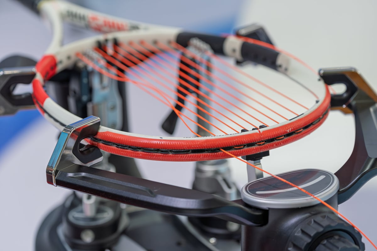 Professional tennis racket stringing work on specialized equipment