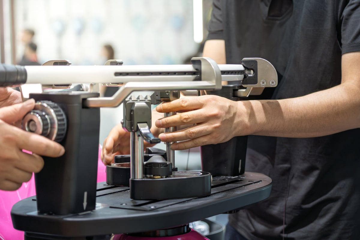 Professional staff operating equipment to string a tennis racket